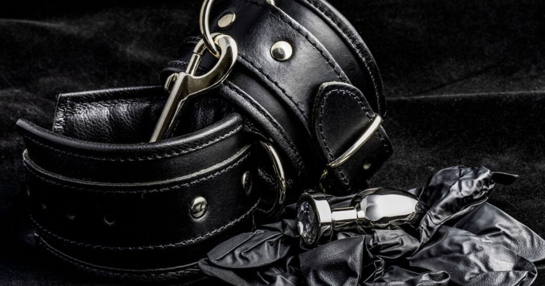 Black leather cuffs on a black background.